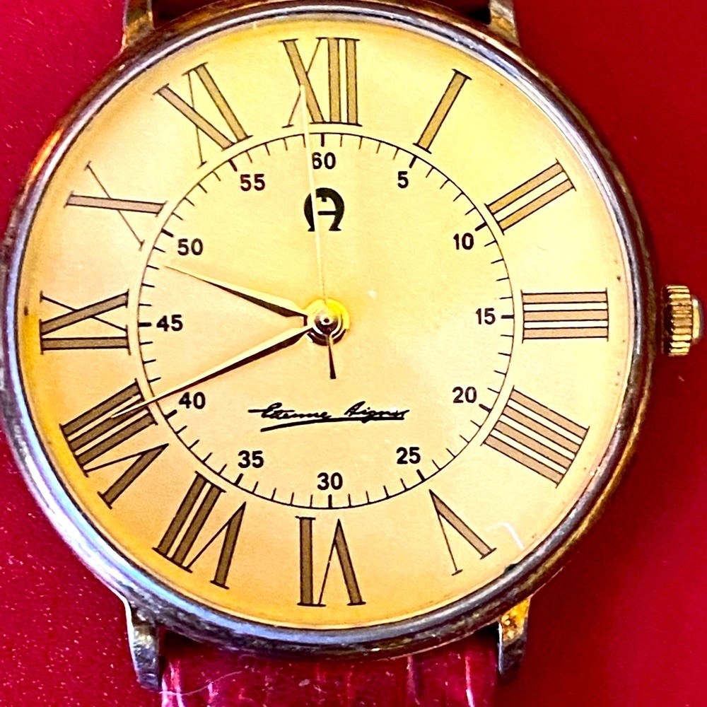 Slim Aigner watch with faux red, snakeskin band.